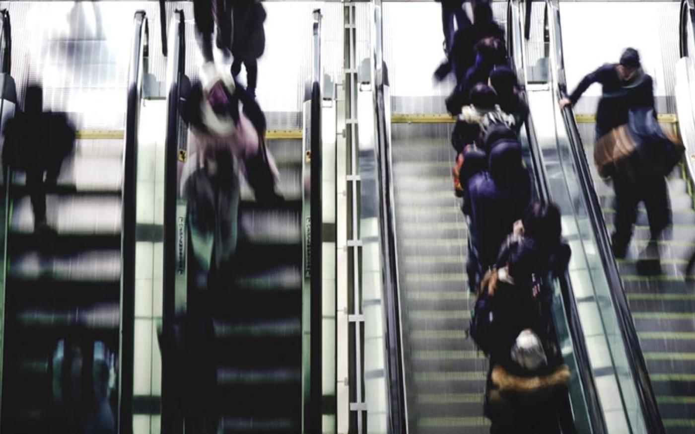 people running up and down escalators